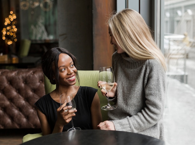 Positieve jonge vrouwen die van een glas wijn genieten