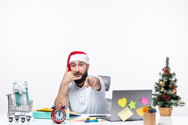 Positieve jonge zakenman met kerstman hoed aan het werk