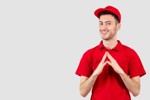 Positieve man in rood uniform staat en kijkt naar voren