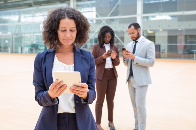 Positieve onderneemster die op inhoud op tablet letten