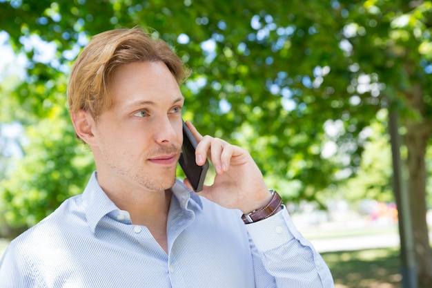 Positieve rustige ondernemer bellen op mobiele telefoon