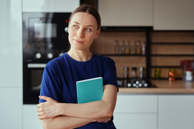 Positieve vrouw die een boek omhelst terwijl het dromen