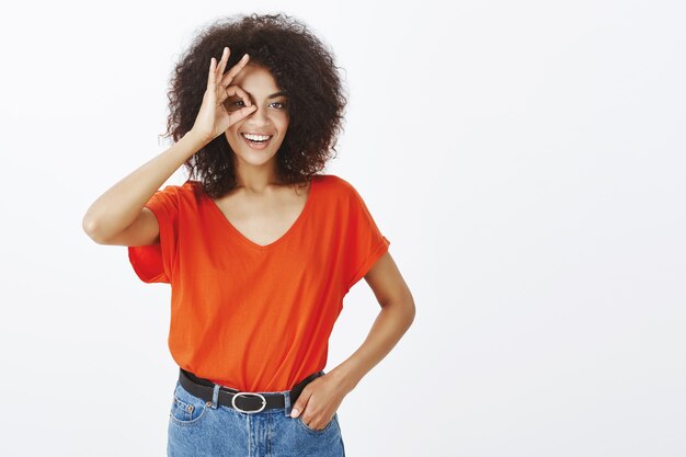 positieve vrouw met afro kapsel poseren in de studio