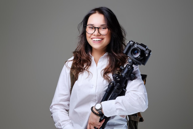 Positieve vrouwelijke toerist met fotocamera en reisrugzak.