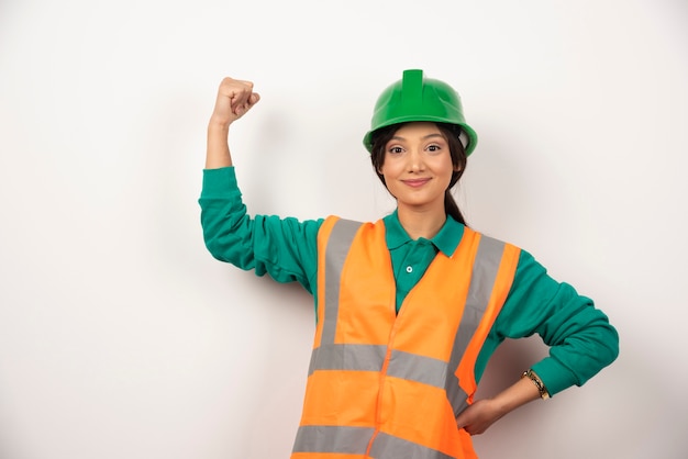 Positieve vrouwelijke werknemer die haar spieren toont