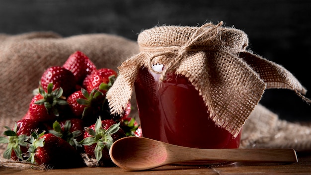 Pot met aardbeienjam en lepel