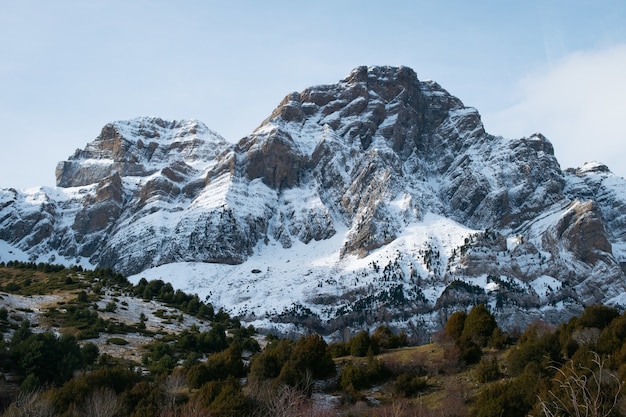 Prachtig bereik van hoge rotsachtige bergen bedekt met sneeuw overdag