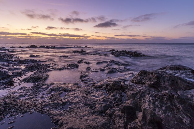 Prachtig landschap van enorme rotsformaties in de buurt van de zee onder de adembenemende zonsonderganghemel