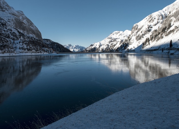 Prachtig landschap van hoge met sneeuw bedekte bergen die reflecteren op het meer in de Dolomieten
