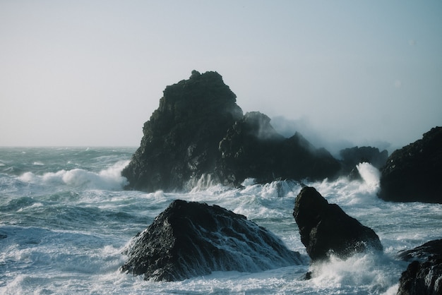 Prachtig landschap van zeegolven die over rotsformaties beuken