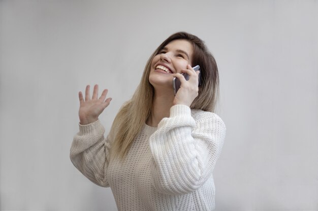 Prachtig shot van een opgewonden vrouw terwijl ze belt vanaf haar telefoon