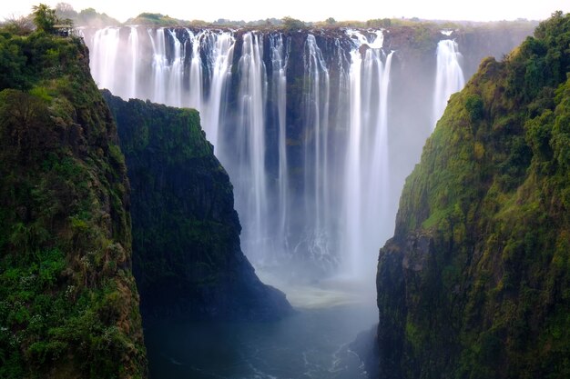 Prachtig shot van een waterval omgeven door bomen en heuvels