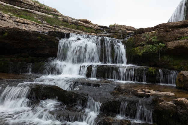 Prachtig uitzicht op de waterval die langs de met mos bedekte kliffen naar beneden stroomt