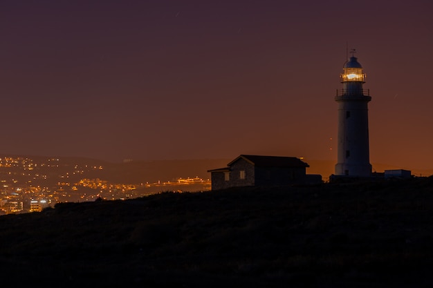 Prachtig uitzicht op een vuurtoren en een huis op een heuvel 's nachts gevangen in Cyprus