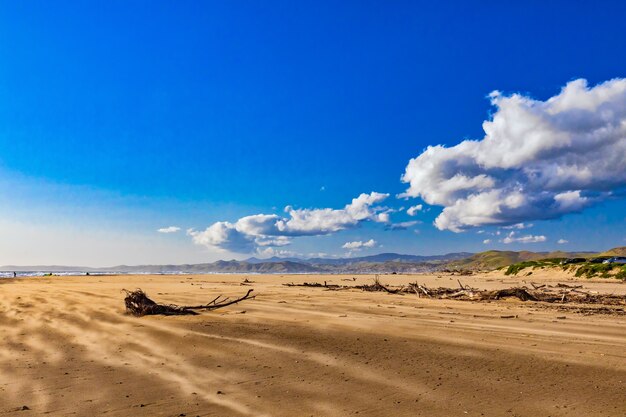 Prachtig uitzicht op het zandstrand aan zee onder de prachtige wolken aan de hemel