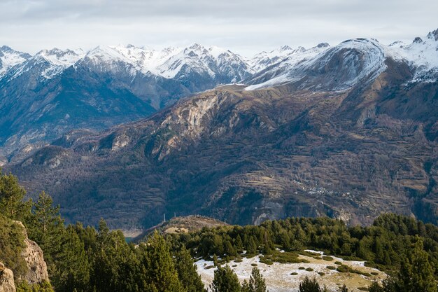 Prachtige bergketen bedekt met sneeuw gehuld in mist - ideaal voor een natuurlijk behang