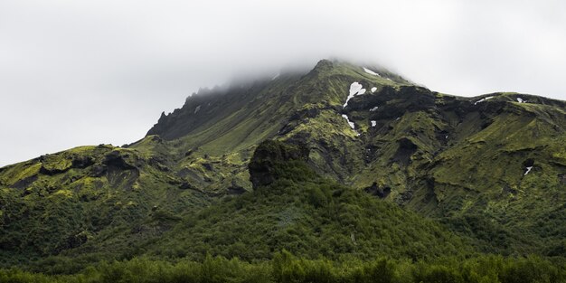 Prachtige bergketen bedekt met sneeuw gehuld in mist - ideaal voor een natuurlijk behang