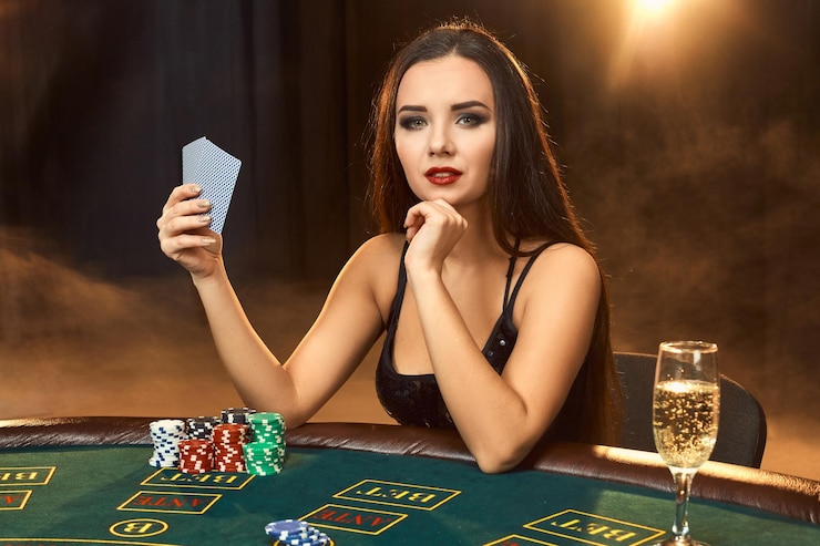 Gratis Foto prachtige emotionele jonge vrouw in een zwarte jurk zittend aan de pokertafel met een glas champagne. laat de rook. poker. casino