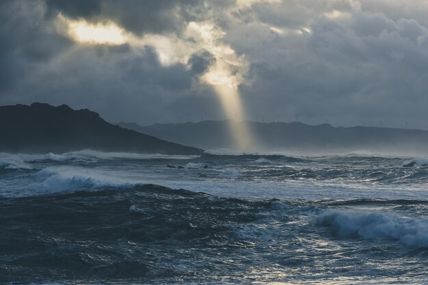 Prachtige golven van de stormachtige oceaan vastgelegd op een bewolkte avond