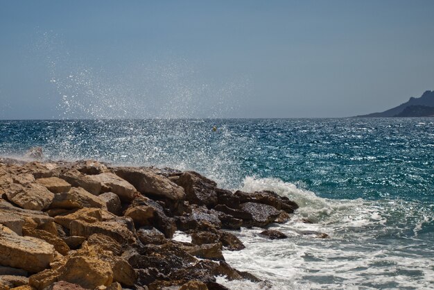 Prachtige oceaangolven komen naar de rotsachtige kusten die in Cannes zijn vastgelegd