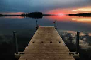 Gratis foto prachtige omgeving van een houten dok aan zee bij zonsondergang