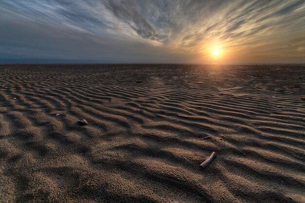 Prachtige zonsondergang op het strand, het perfecte decor voor avondwandelingen aan de kust