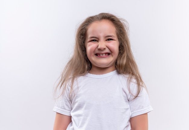 Precies klein schoolmeisje dat witte t-shirt op geïsoleerde witte achtergrond draagt