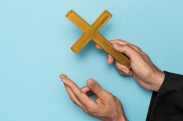 Priester met kruisvinger en houten kruis