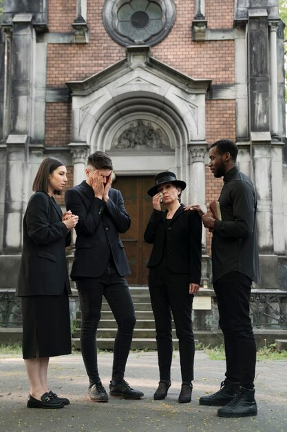Priester troost rouwende familie buiten de kerk