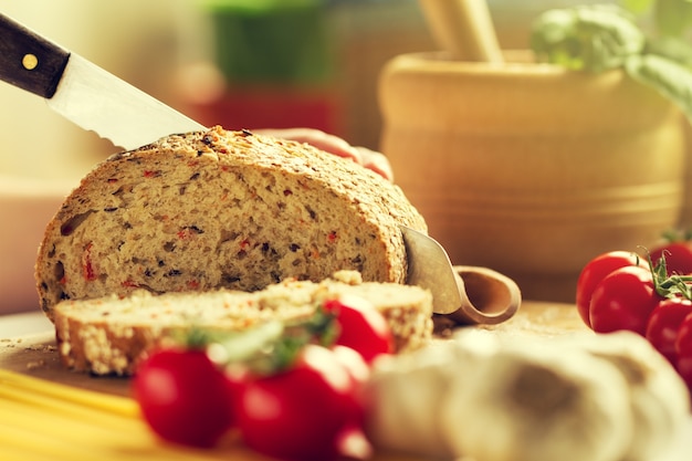 Proces van het snijden van volkorenbrood in de keuken. Keukenachtergrond. Kookproces. Afgezwakt.