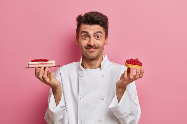 Professionele banketbakker werkt in patisserie, houdt lekkere handgemaakte taarten, vormt in de keuken van het restaurant, draagt een wit uniform