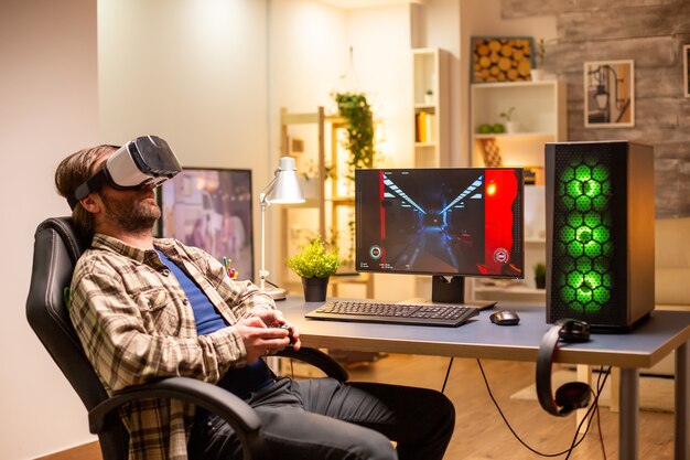 Professionele gamer die een VR-headset gebruikt om 's avonds laat in zijn woonkamer op een krachtige pc te spelen