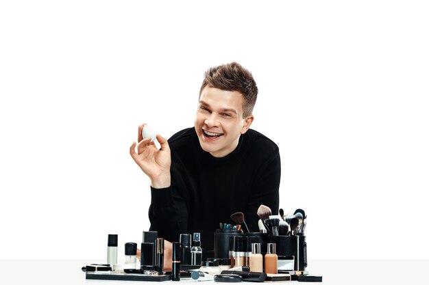 Professionele make-up artist met tools op wit wordt geïsoleerd. De man in vrouwelijk beroep. gendergelijkheid concept