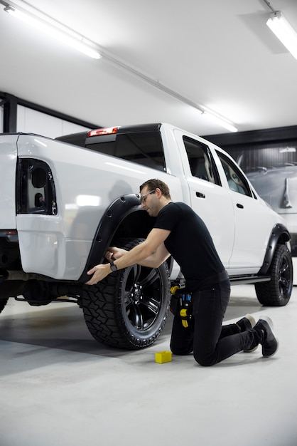 Professionele man aan het werk aan auto volledig schot