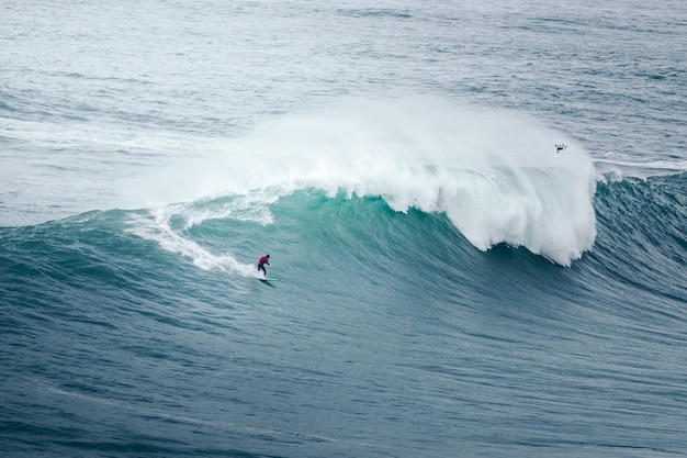 Professionele surfer berijdt een gigantische golf
