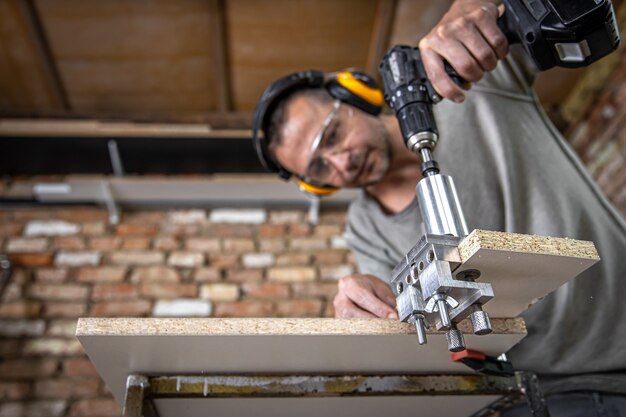 Professionele timmerman die met hout werkt en gereedschappen in huis bouwt.