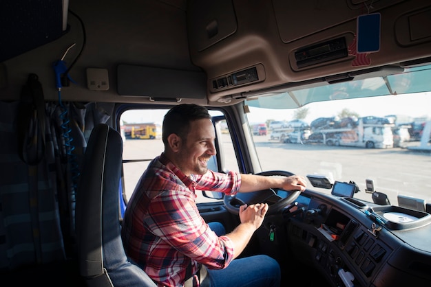 Professionele vrachtwagenchauffeur met glimlachende vrachtwagen en op tijd afleveren van goederen