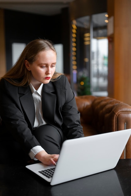 Professionele vrouw in stijlvol pak op kantoor met laptop