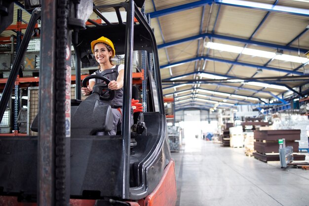 Professionele vrouwelijke industriële chauffeur heftruck machine in fabriekshal