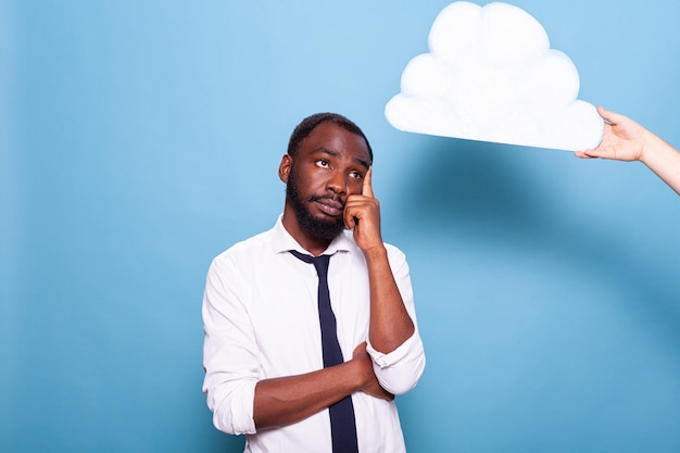 Professionele zakenman kijken naar witboek idee wolk concept staande met gekruiste armen en vinger wijzend naar hoofd. afro-amerikaanse ondernemer brainstormen naast gedachte zeepbel.