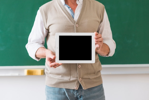 Professor die tablet met lege ruimte in klaslokaal houdt