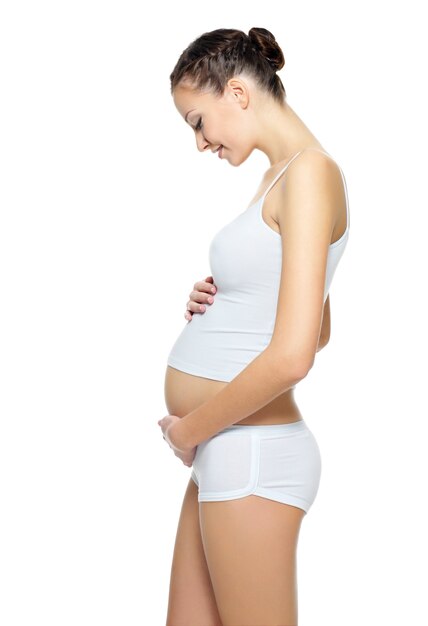 Profiel portret van het mooie zwangere vrouw poseren geïsoleerd op wit