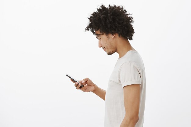Profiel van :: jonge stedelijke man met behulp van mobiele telefoon, vriend sms'en op sociale media, bankrekening controleren