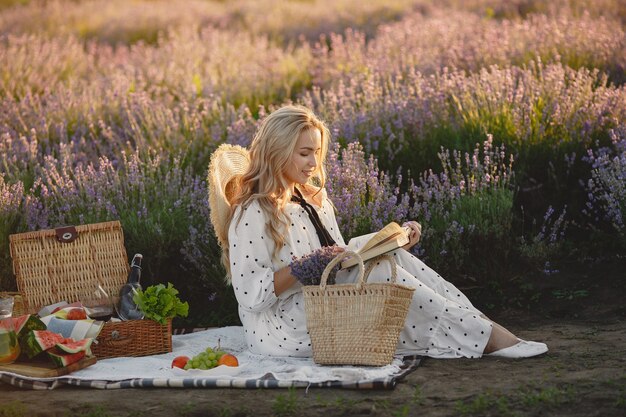 Provence vrouw ontspannen in lavendel veld. Dame in een picknick. Vrouw met een strohoed.