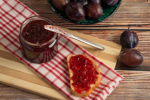 Pruimen met een potje confituur en een toastbroodje.