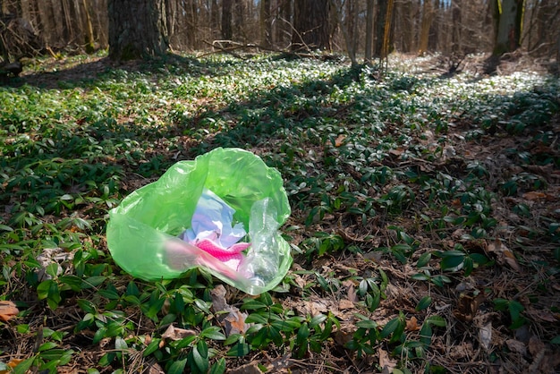 Prullenbak rond de bomen in het bos. puin, plastic afval. milieuvervuiling. ecologisch probleemconcept. vuilnis en afval op de natuur. Premium Foto