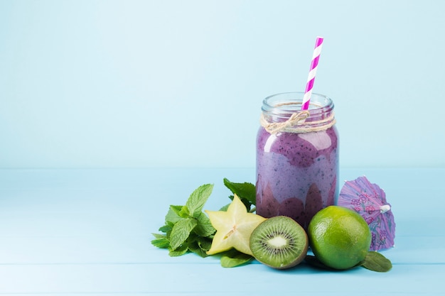 Purpere smoothiekruik op blauwe achtergrond