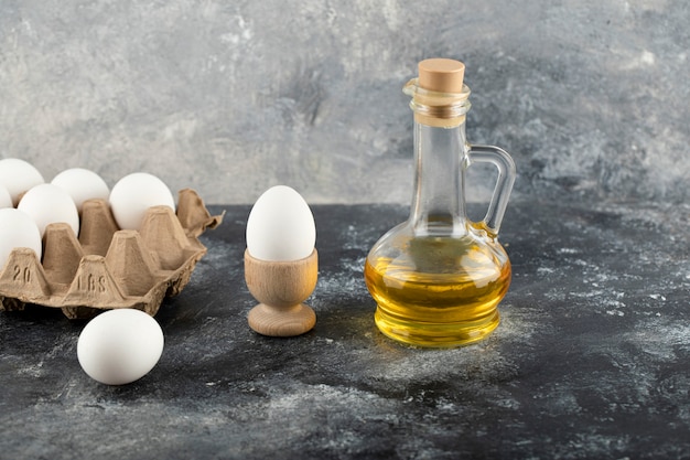 Rauw kippenei in eierdopje met eggbox op een marmeren oppervlak.