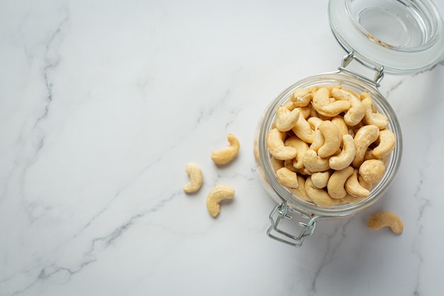 Gratis foto rauwe cashewnoten in een open glazen pot op marmeren achtergrond