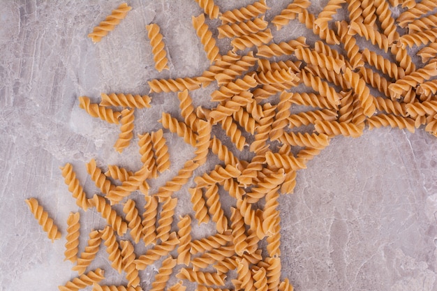 Rauwe en ongekookte pasta's geïsoleerd op het marmeren oppervlak